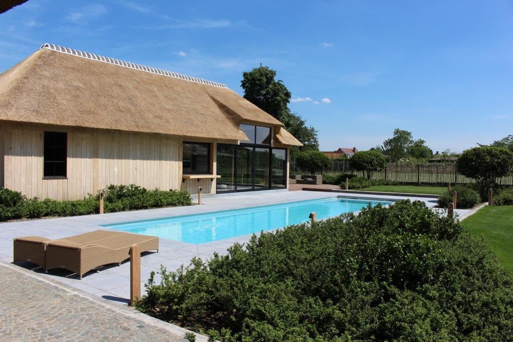 PPC-zwembad met houten poolhouse in een verzorgde tuin